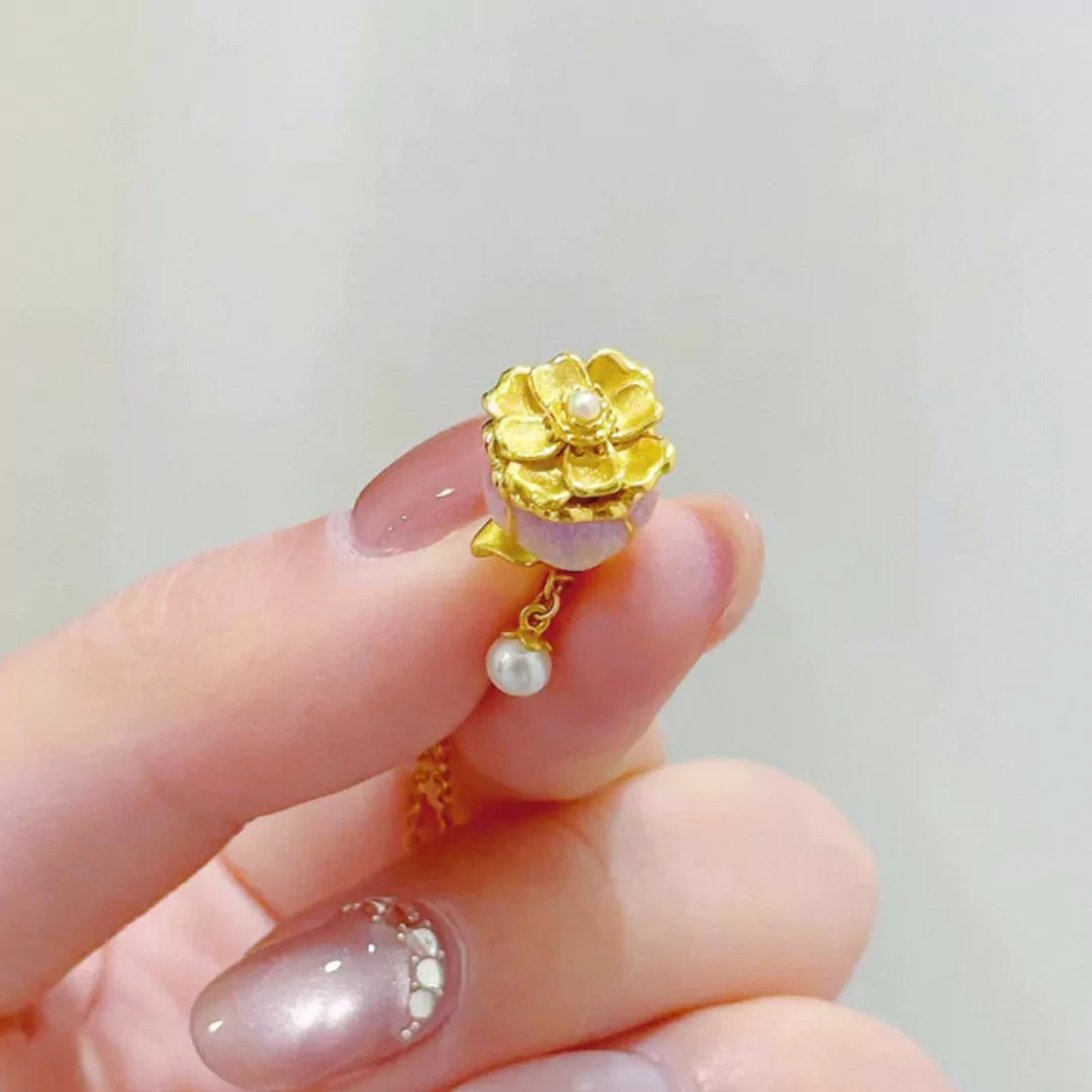 Detailansicht der Aurora Glockenblume Halskette: Fein gearbeitete, goldene Blütenstempel, die sich sanft bewegen, mit einer schimmernden Perle im Zentrum – ein Symbol für Liebe und Eleganz.