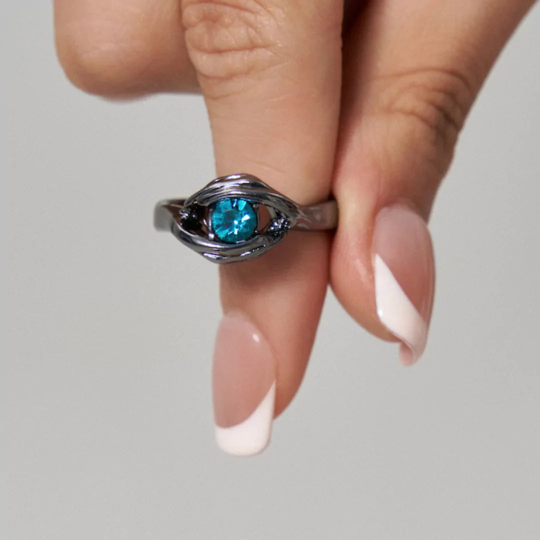 Nahaufnahme des blauen Edelsteins im Zentrum des schwarzen Ewige Liebe-Rings – intensiv funkelnd und elegant gefasst