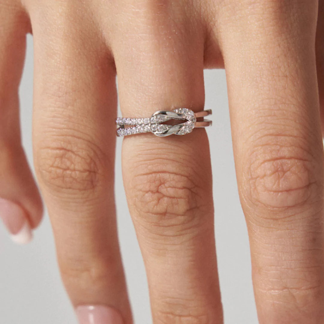 Knoten-Ring an der Hand getragen – feines Design als Symbol für Liebe und Zusammenhalt