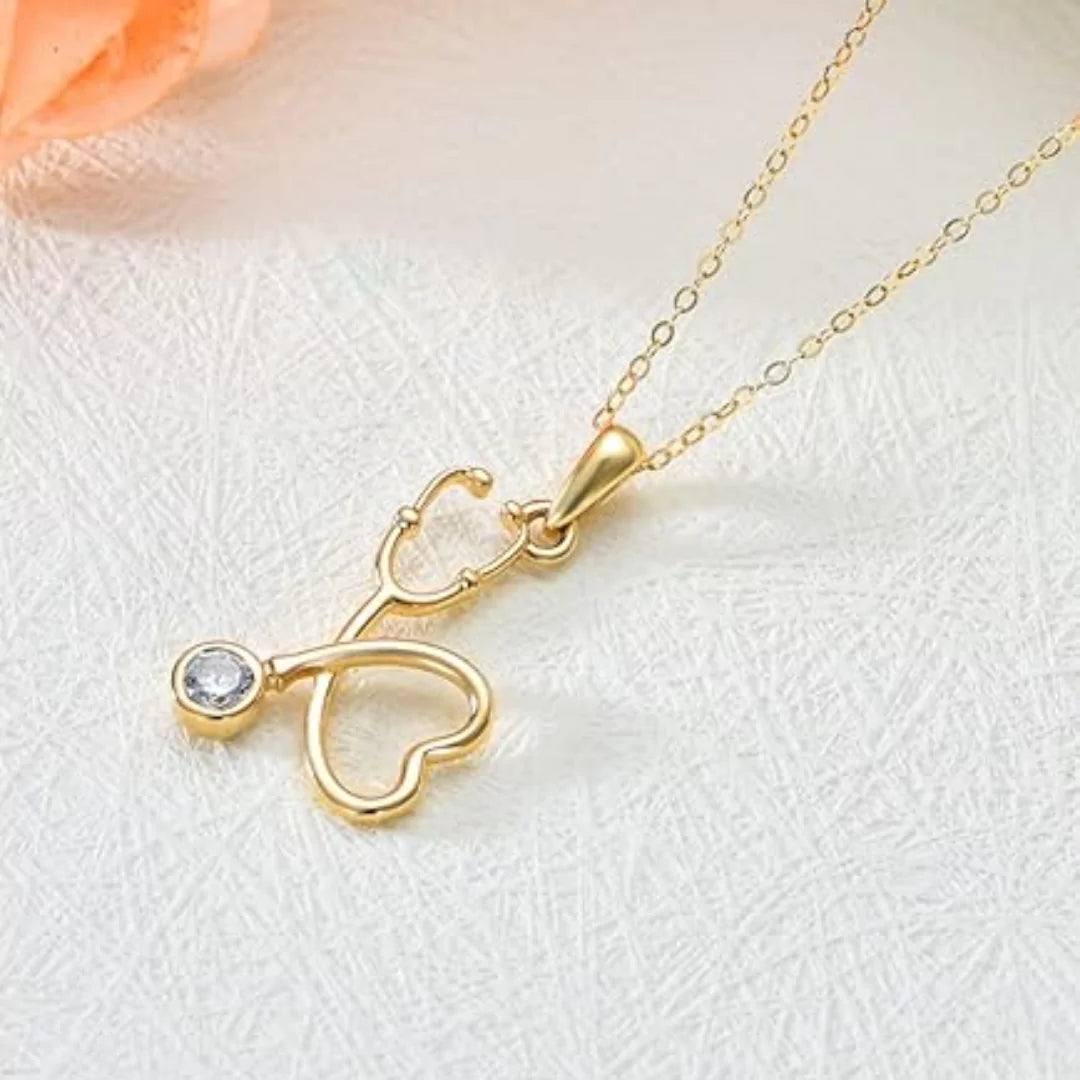 Makroaufnahme der goldenen Stethoskop-Halskette mit funkelndem Zirkonia in der Membran – feine Handwerkskunst im Detail