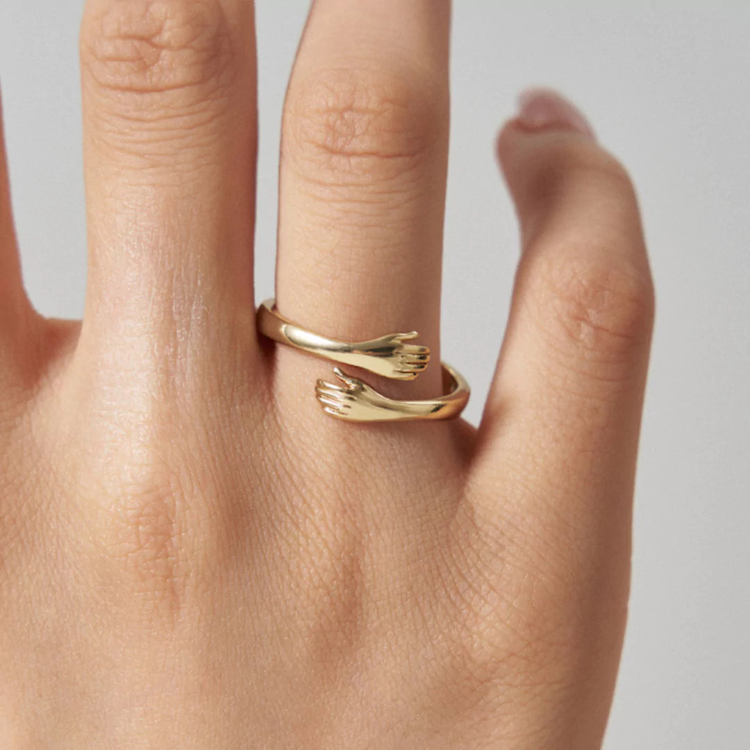 Zarter Umarmungsring in Gold am Finger getragen – eleganter Liebesbeweis mit Bedeutung