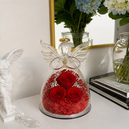 Großer Glasengel mit drei roten Rosen auf einer eleganten weißen Konsole