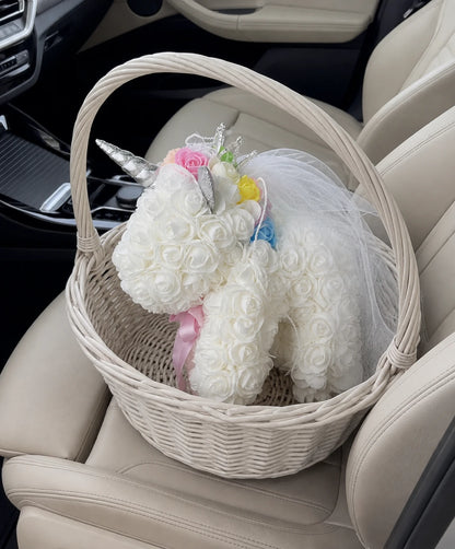 White rose unicorn styled in a woven gift basket on a car seat