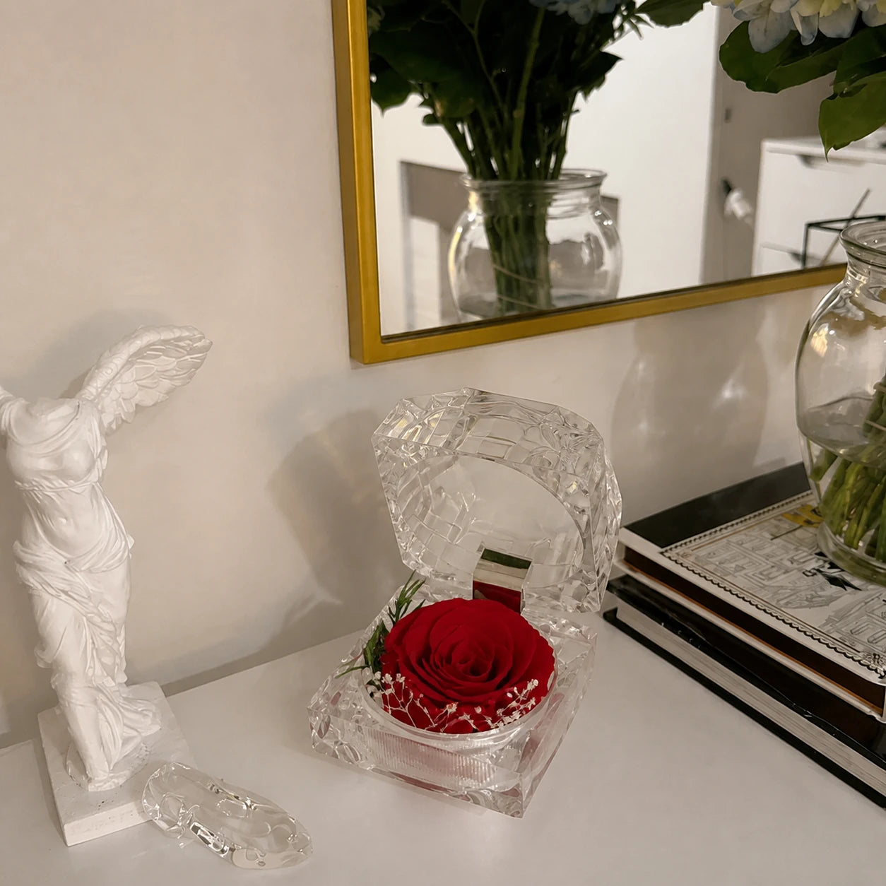 Acrylbox mit roter konservierter Rose auf einem eleganten Tisch