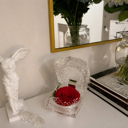 Acrylbox mit roter konservierter Rose auf einem eleganten Tisch