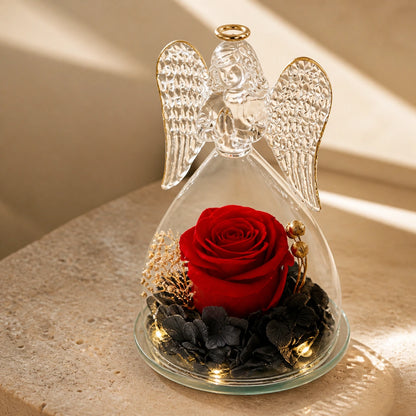Detail des kleinen Glasengels mit einer roten Rose, dunkler Hortensie und Licht