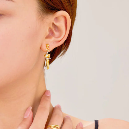 Model kombiniert Umarmungs-Ohrringe mit Alltagsoutfit – zarte Goldakzente für jeden Stil