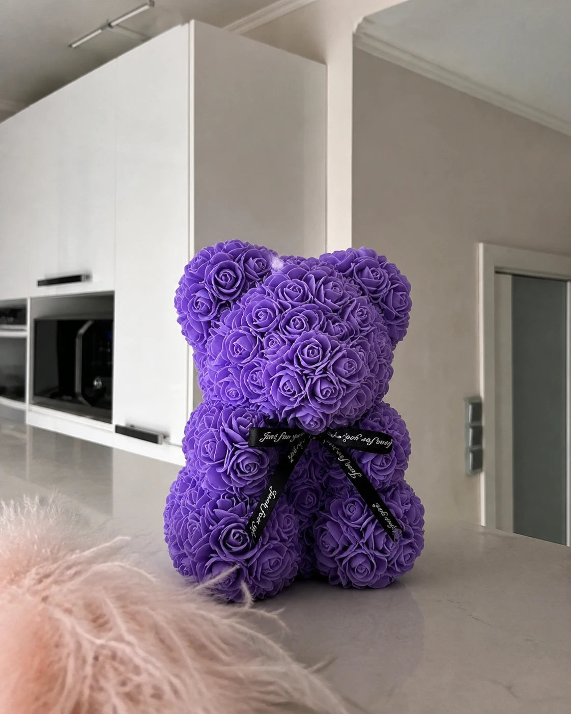 Lavender rose teddy bear on a softly lit kitchen counter