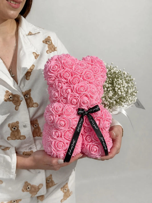 Light pink rose teddy bear held in both hands at home