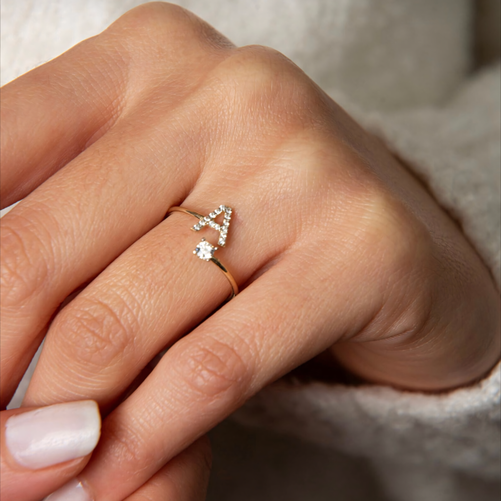 Frau trägt den Swaravo Initialen-Ring mit dem Buchstaben A – funkelnder Schmuck mit persönlicher Bedeutung in Gold