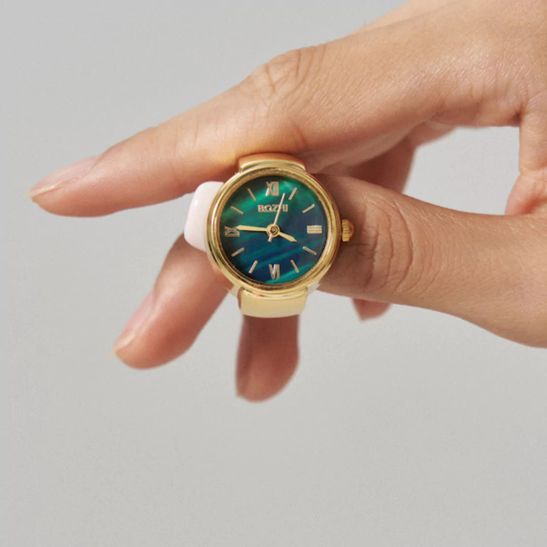 Stilvolle Damen-Ringuhr in Gold mit Mini-Zifferblatt – getragen als modisches Statement mit Vintage-Flair.