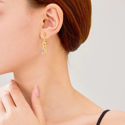 Close-up einer Frau mit 14k vergoldeten Ohrringen in Umarmungsform – Zeichen von Nähe und Liebe