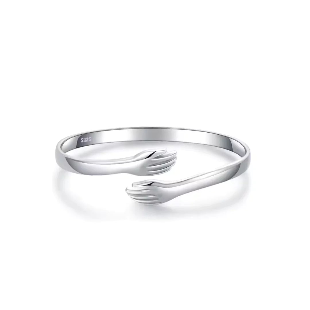 Nahaufnahme des Umarmungsarmbands aus Sterlingsilber mit zwei sich umarmenden Figuren
