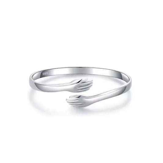 Nahaufnahme des Umarmungsarmbands aus Sterlingsilber mit zwei sich umarmenden Figuren