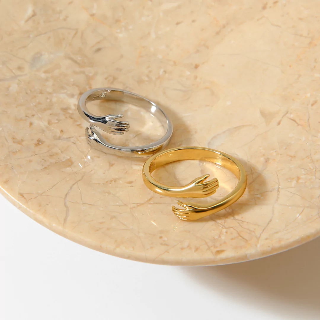 Zwei Umarmungsringe in Gold und Silber am Finger getragen – stilvoller Schmuck mit emotionaler Bedeutung