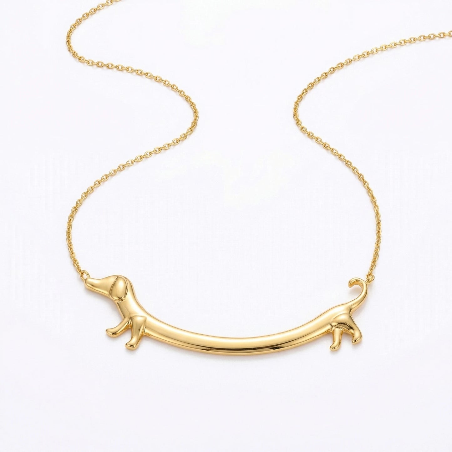 Goldene Dackel Smile Halskette auf weißem Hintergrund