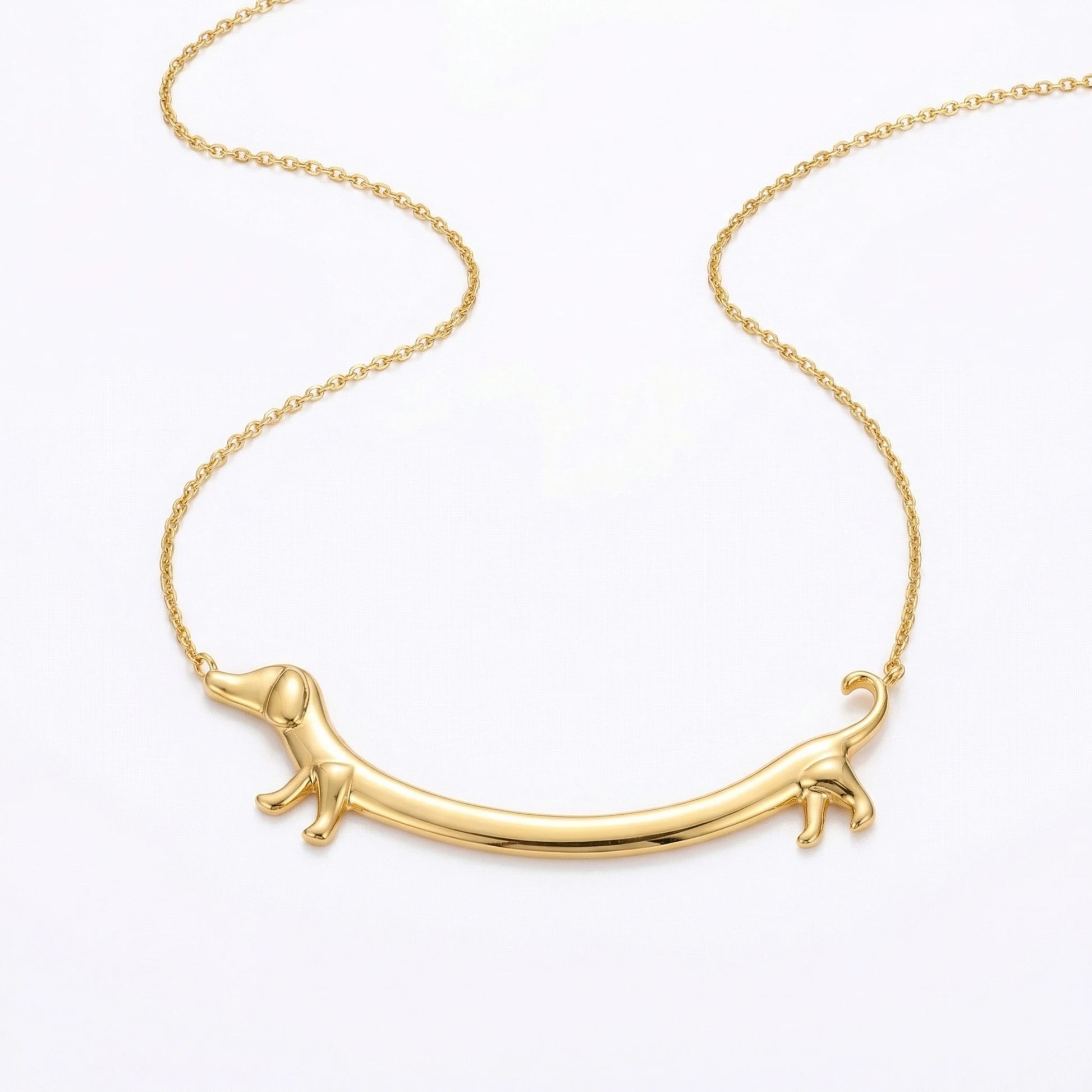 Goldene Dackel Smile Halskette auf weißem Hintergrund