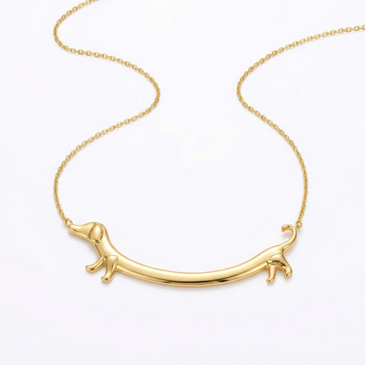 Goldene Dackel Smile Halskette auf weißem Hintergrund